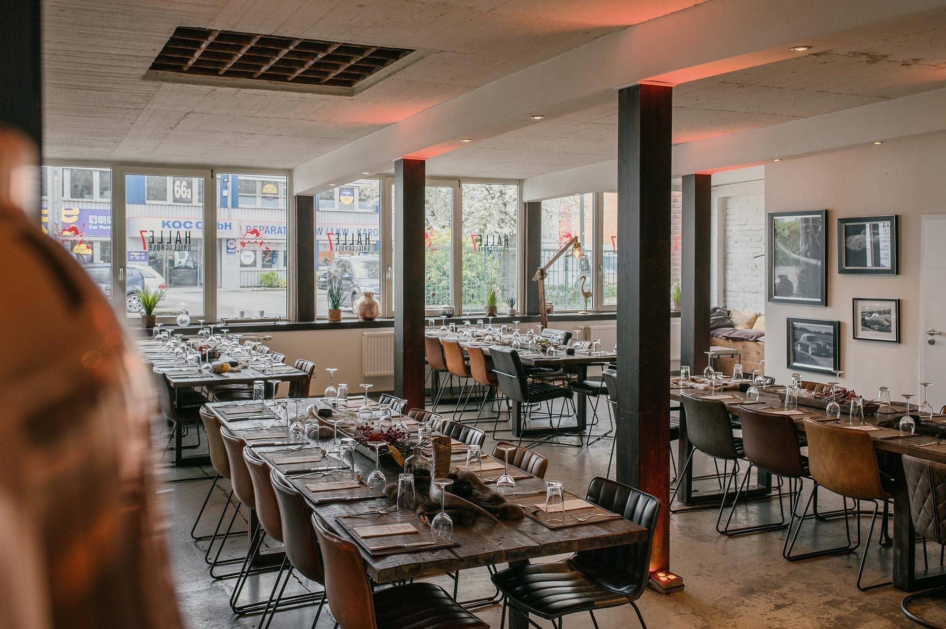 Die Eventhalle im Das Grillfachgeschäft in Düsseldorf mit langen, gedeckten Tafeln